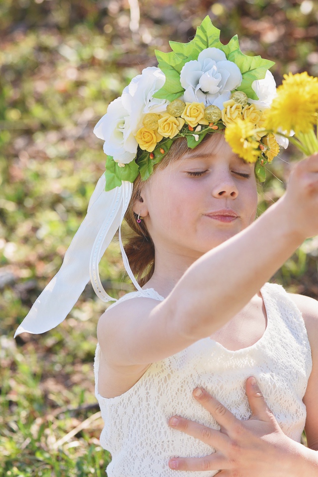Маленькая девочка с букетом одуванчиках в руке 
