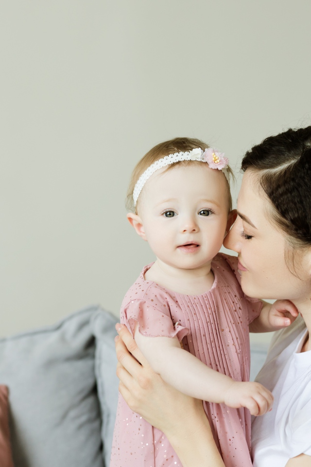 Маленькая девочка с мамой на сером фоне