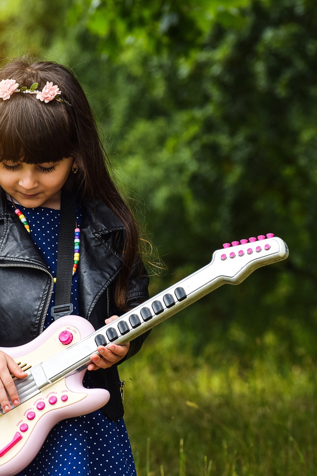 Маленькая девочка с игрушечной гитарой
