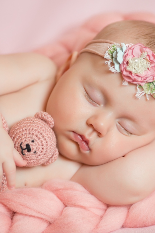 Маленькая новорожденная девочка с вязаным мишкой 