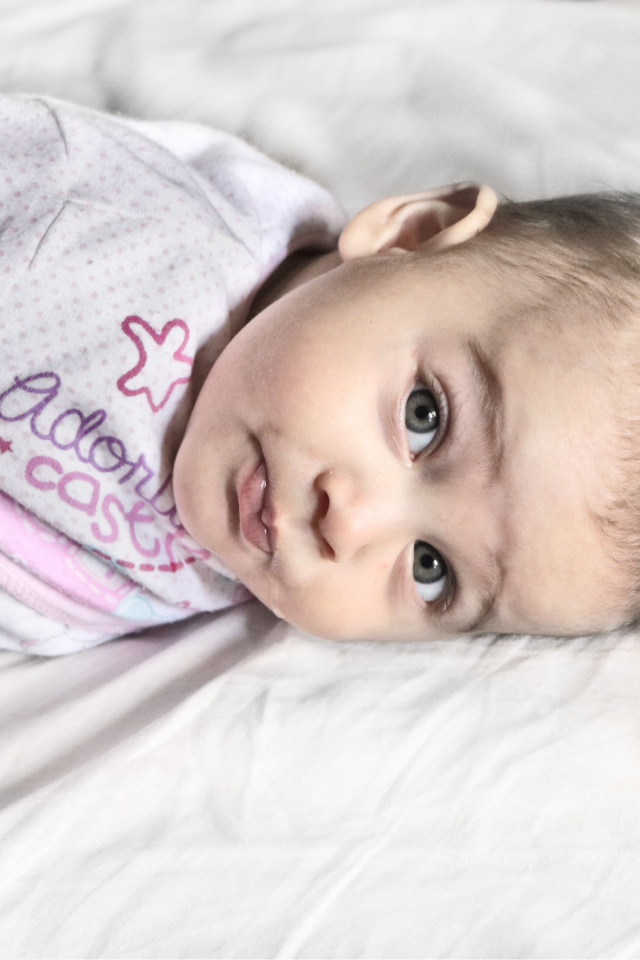 Маленький новорожденный ребенок лежит на кровати 