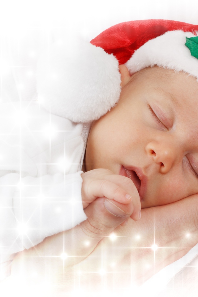Маленький спящий ребенок в новогодней шапке 