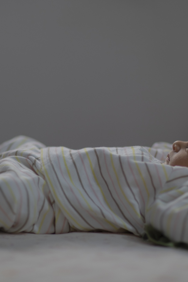 Маленький спящий грудной ребенок на кровати 