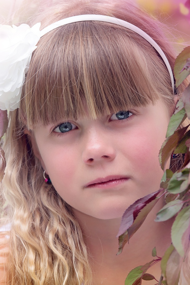 Грустная маленькая девочка у ветки дерева 