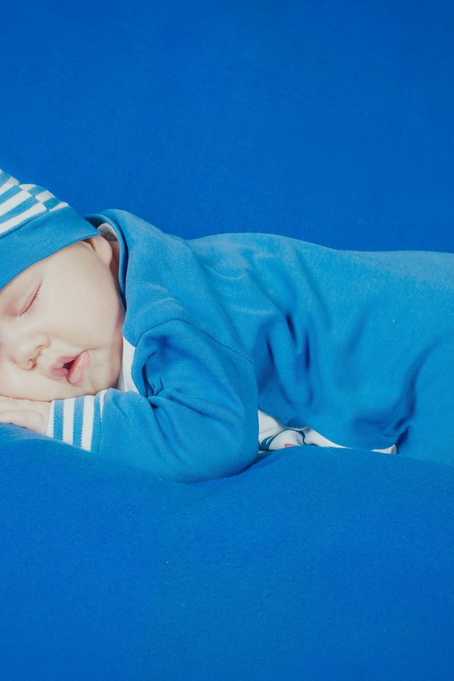 Спящий грудной ребенок в голубом костюме 