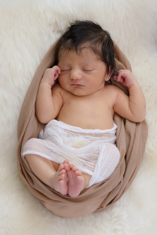 Спящий грудной ребенок на меховом покрывале 