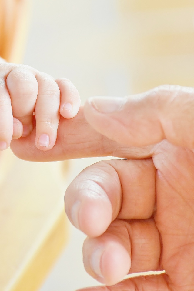 Маленькая рука ребенка держит руку взрослого