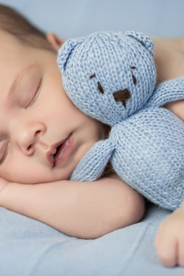 Маленький грудной ребенок с вязаным мишкой