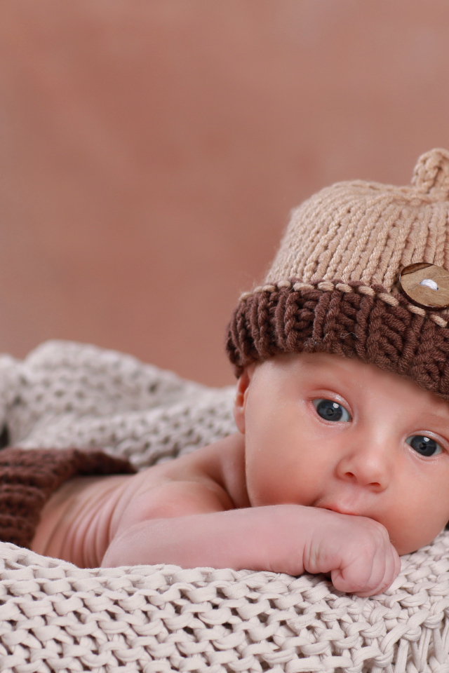 Маленький грудной ребенок в вязаном костюме 