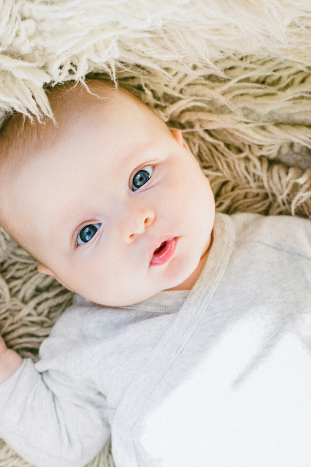 Маленький грудной ребенок на меховом покрывале 