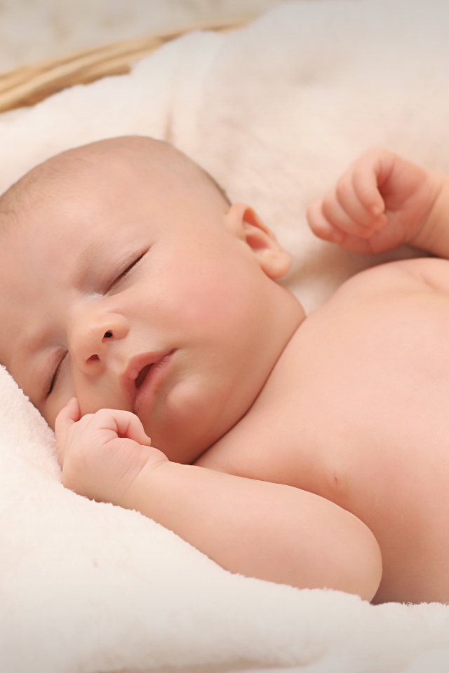 Маленький грудной ребенок спит в корзине 