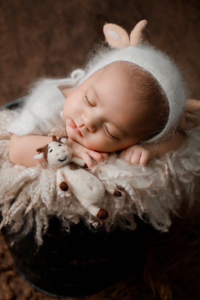 Маленький грудной ребенок спит в ведре