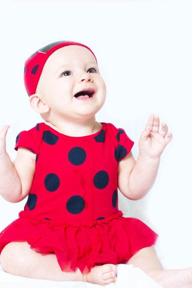 Улыбающаяся девочка в красном платье с черными кругами