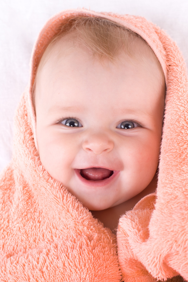 Улыбающийся грудной ребенок в полотенце