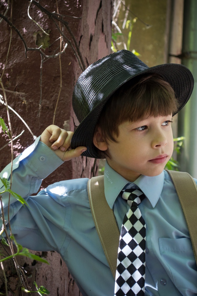 Стильный мальчик в черной шляпе 