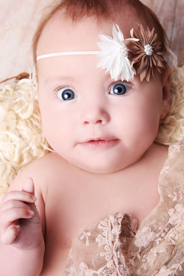 Удивленная голубоглазая новорожденная девочка 