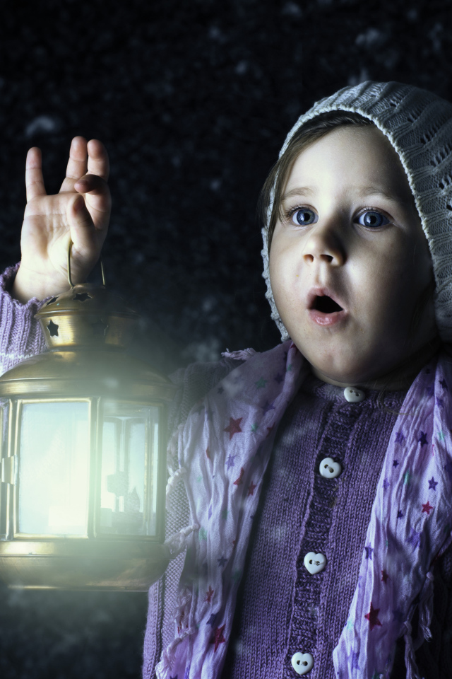 Удивленная маленькая девочка с фонарем в руке