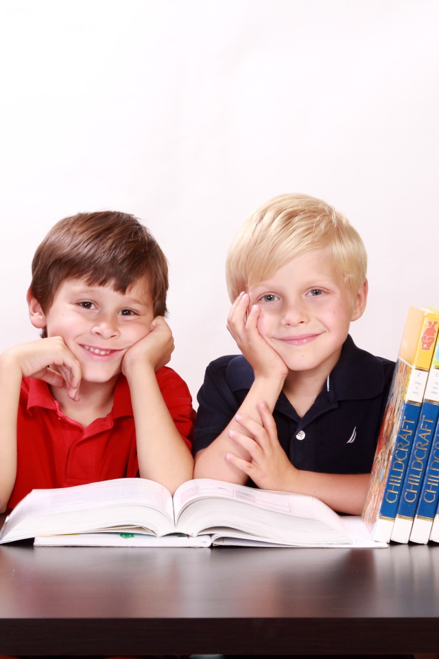 Два школьника за партой с книгами и глобусом 