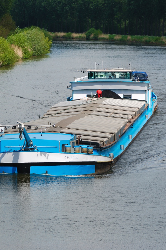 Грузовая баржа плывет по реке 