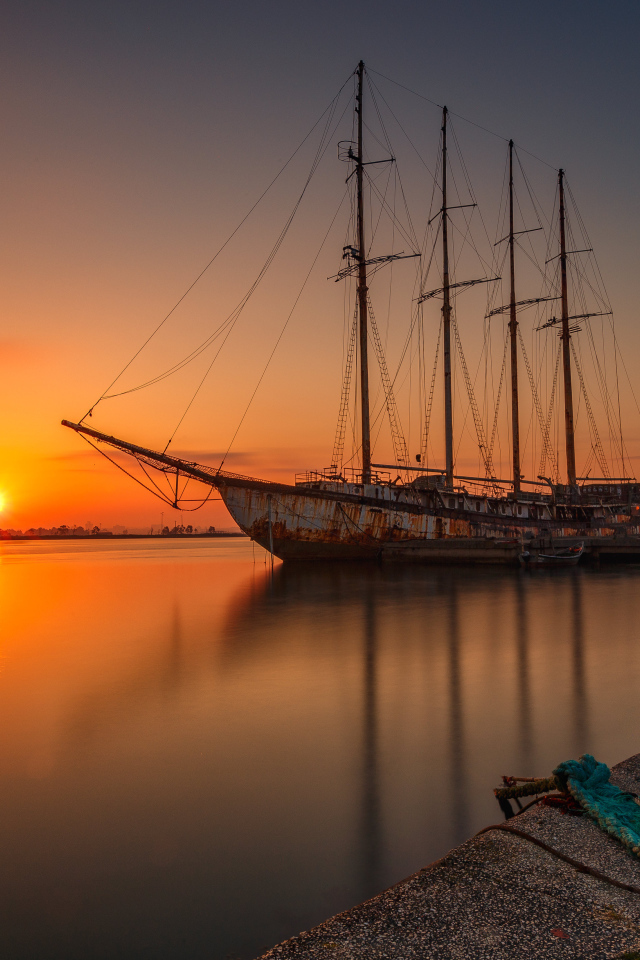 Большой корабль стоит на закате солнца 