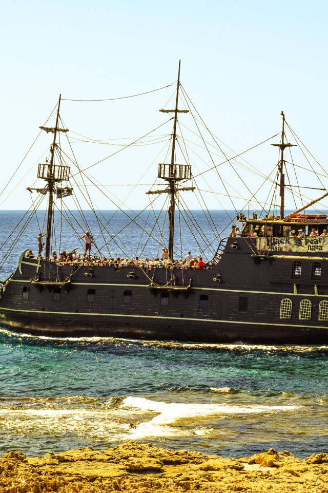 Большой черный пиратский корабль у берега
