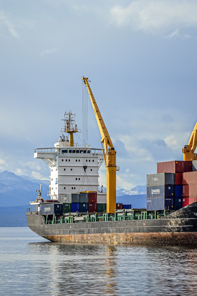 Большой грузовой корабль с контейнерами уходит в рейс 