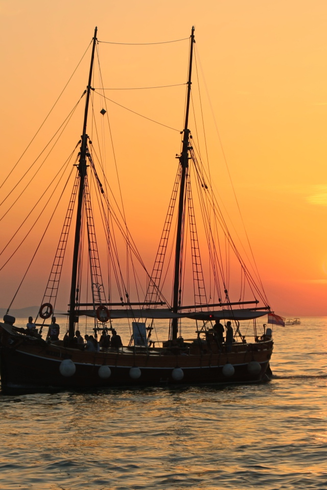 Большой корабль с опущенными парусами на закате солнца 