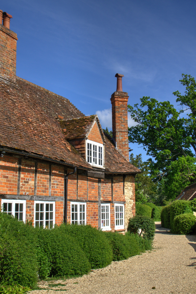 Кирпичный старый дом под голубым небом, Англия 