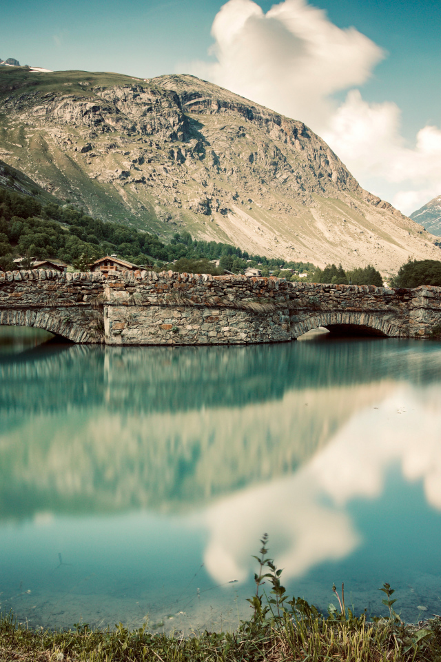 Старый кирпичный мост на озере у горы,Франция