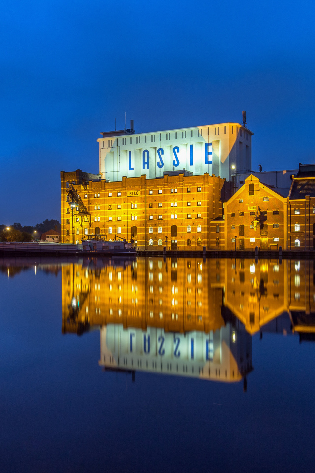 Здание завода у воды ночью, Нидерланды