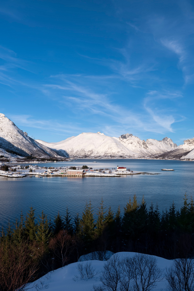 Покрытые снегом горы под голубым небом у воды, Норвегия