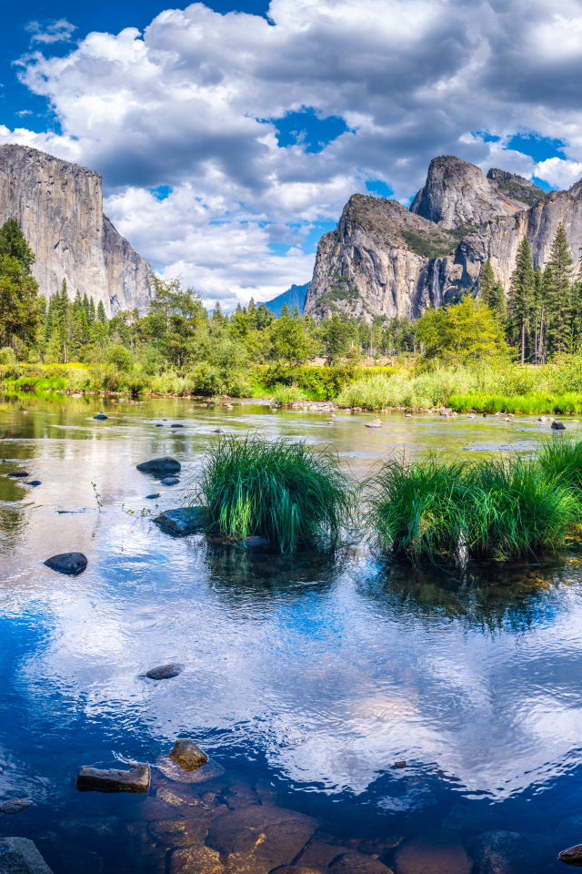 Спокойная вода в озере на фоне гор под белыми облаками, США 