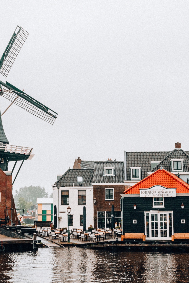 Мельница и дома на берегу реки 