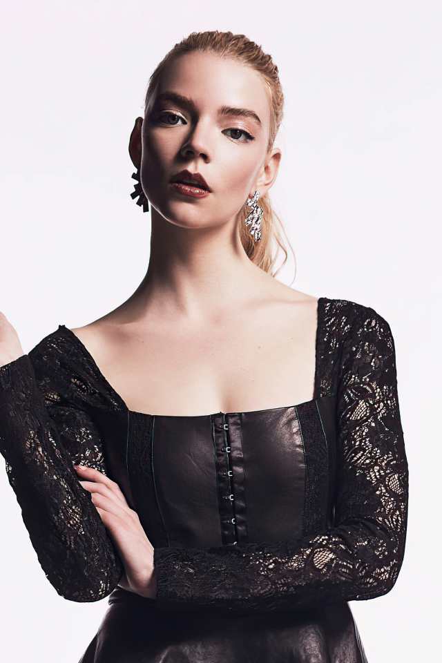 Актриса Аня Тейлор-Джой в черном наряде на белом фоне