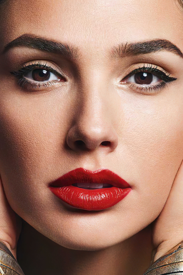 Актриса Галь Гадот крупным планом на сером фоне