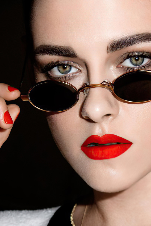 Актриса Кристен Стюарт в очках на  черном фоне