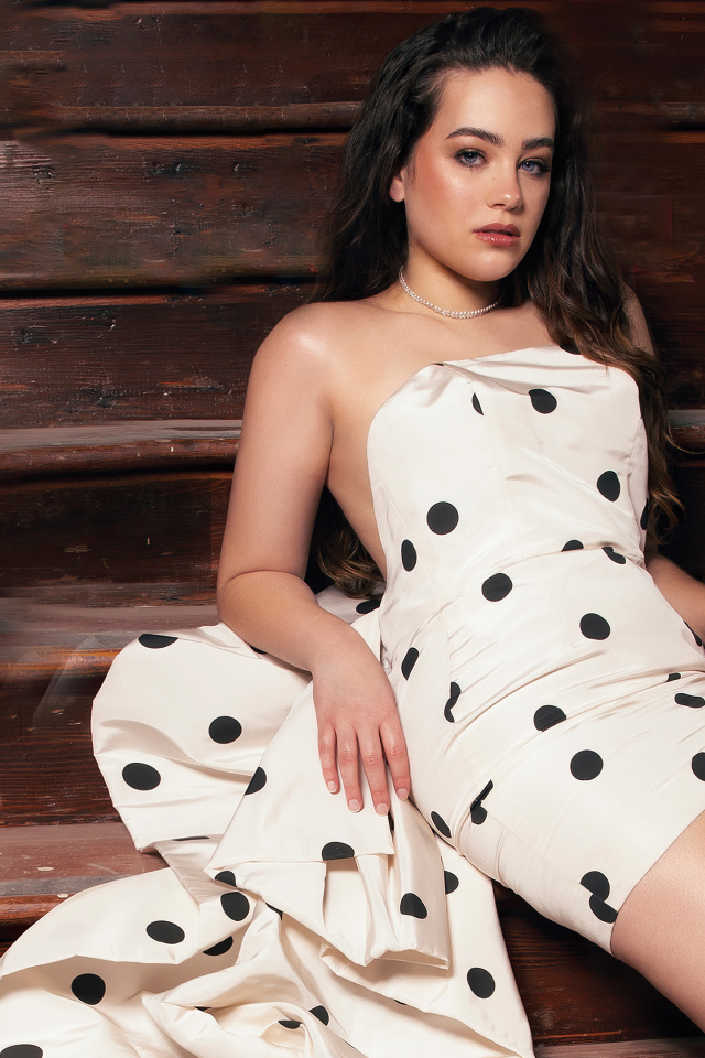 Американская актриса Мэри Маусер в платье сидит на лавке