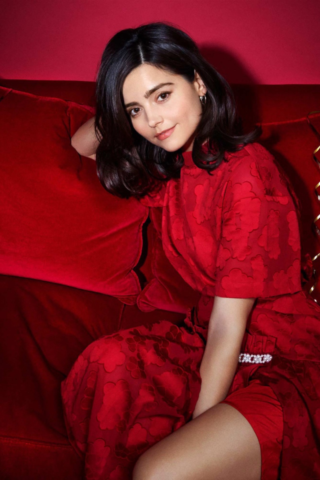 Красивая британская актриса Дженна Коулман сидит на красном диване