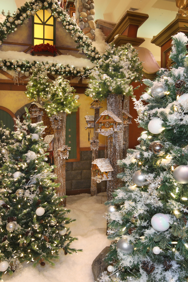 Новогодние ели стоят в комнате с декором 