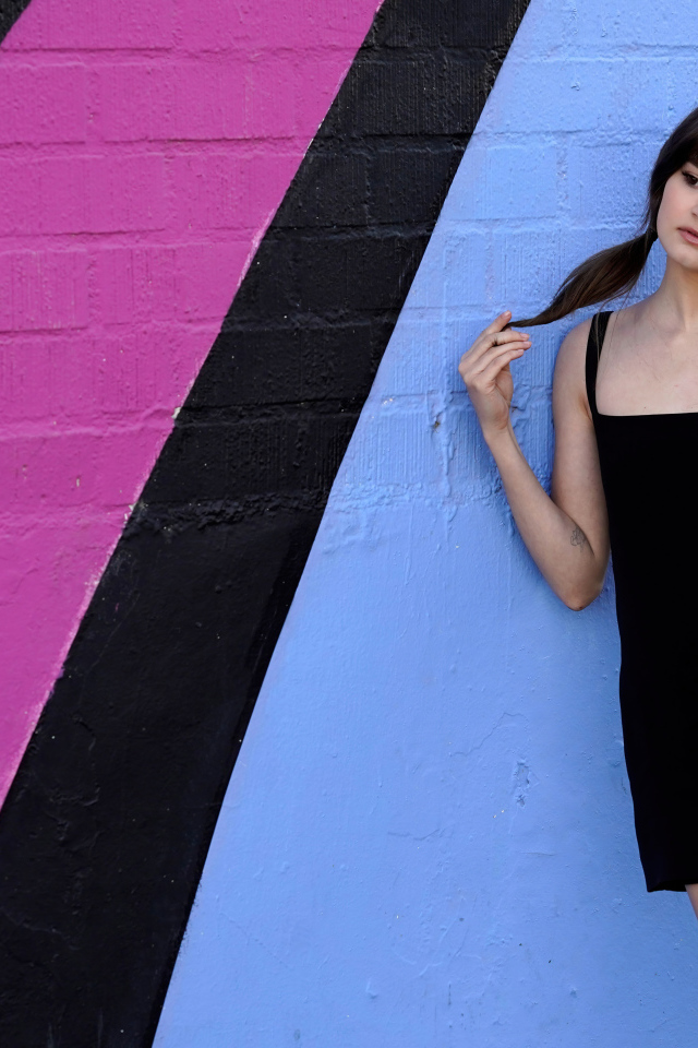 Милая девушка актриса Сиэра Браво у разноцветной стены