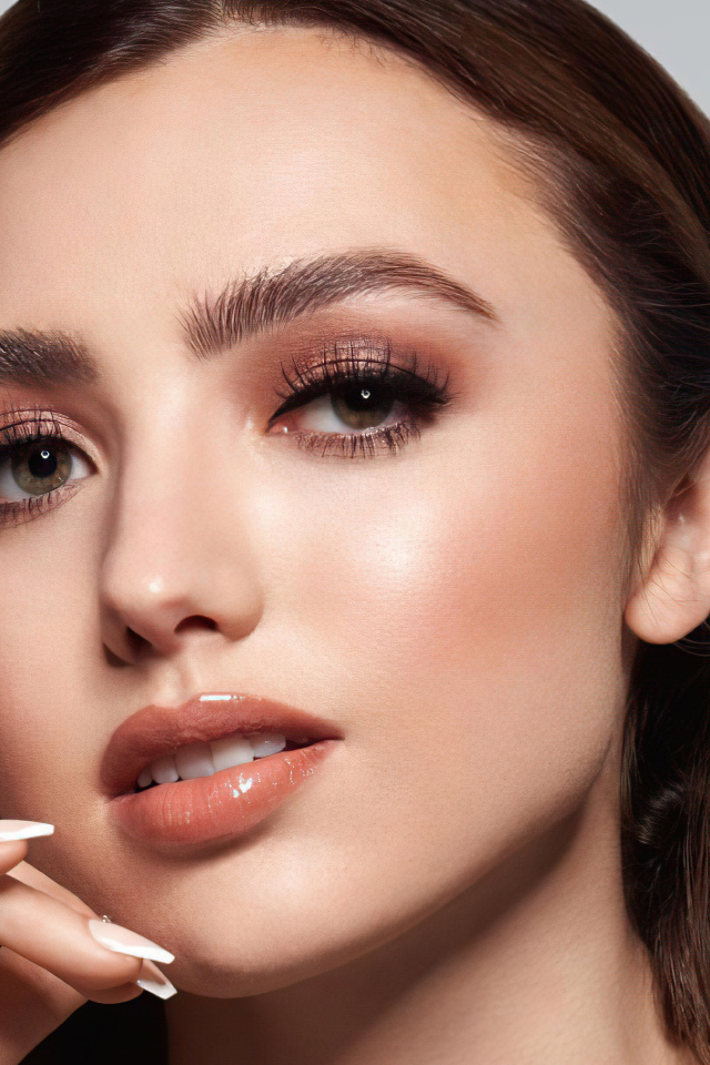 Лицо актрисы Пейтон Лист на сером фоне крупным планом