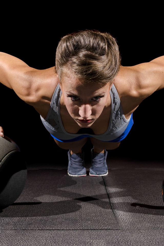 Девушка отжимается с гирями