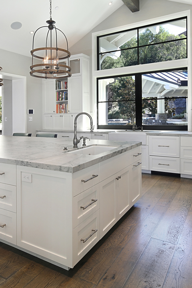 Большой гранитный стол в кухне с белой мебелью 