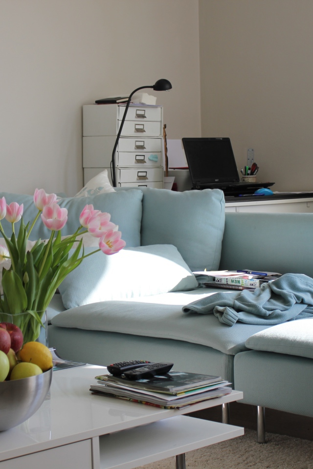 Большой серый диван в гостиной со столом 