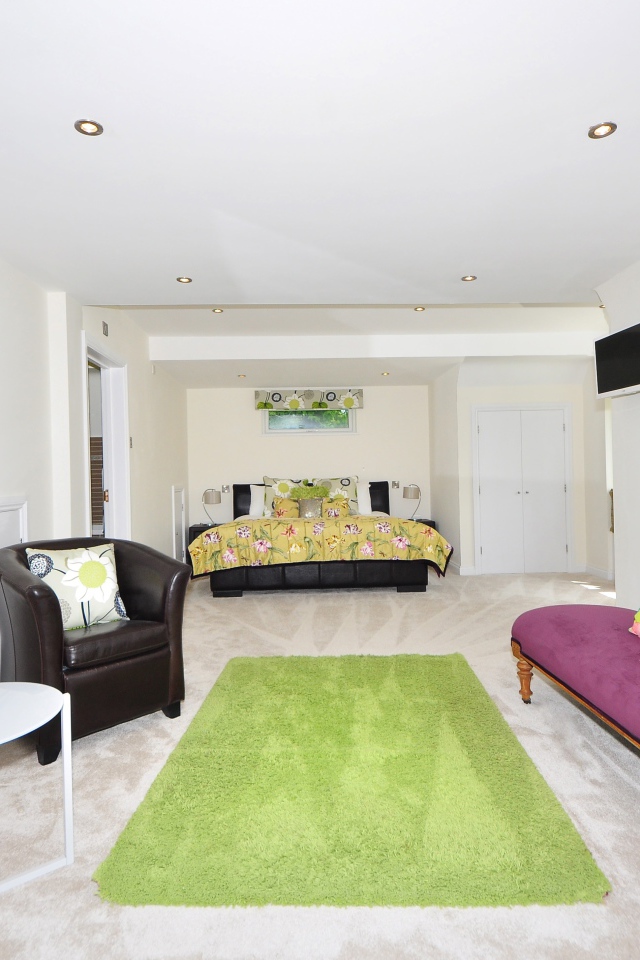 Большая гостиная с высокими белыми стенами и мебелью 