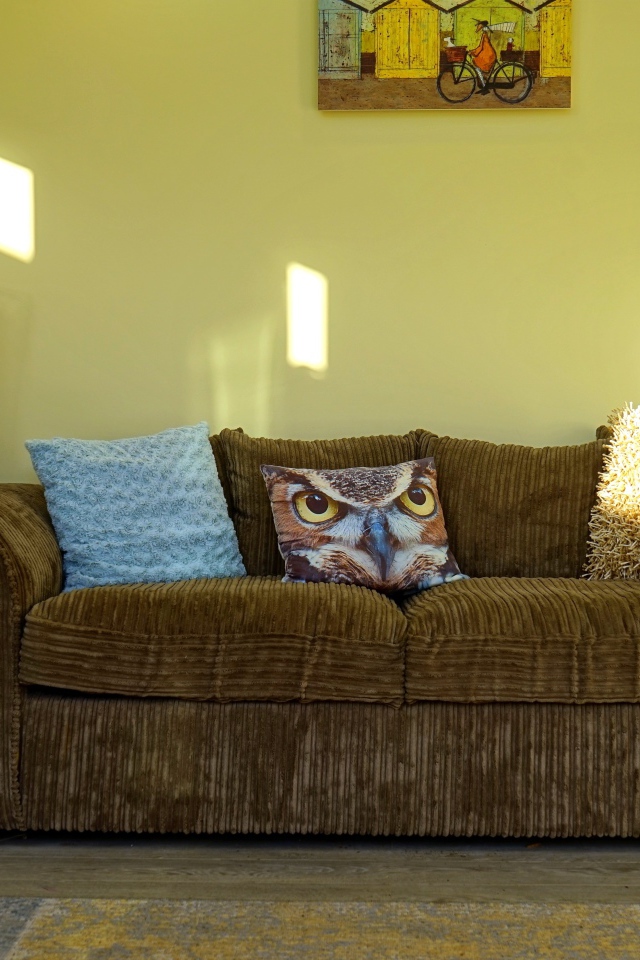 Большой старый диван в комнате с желтыми стенами