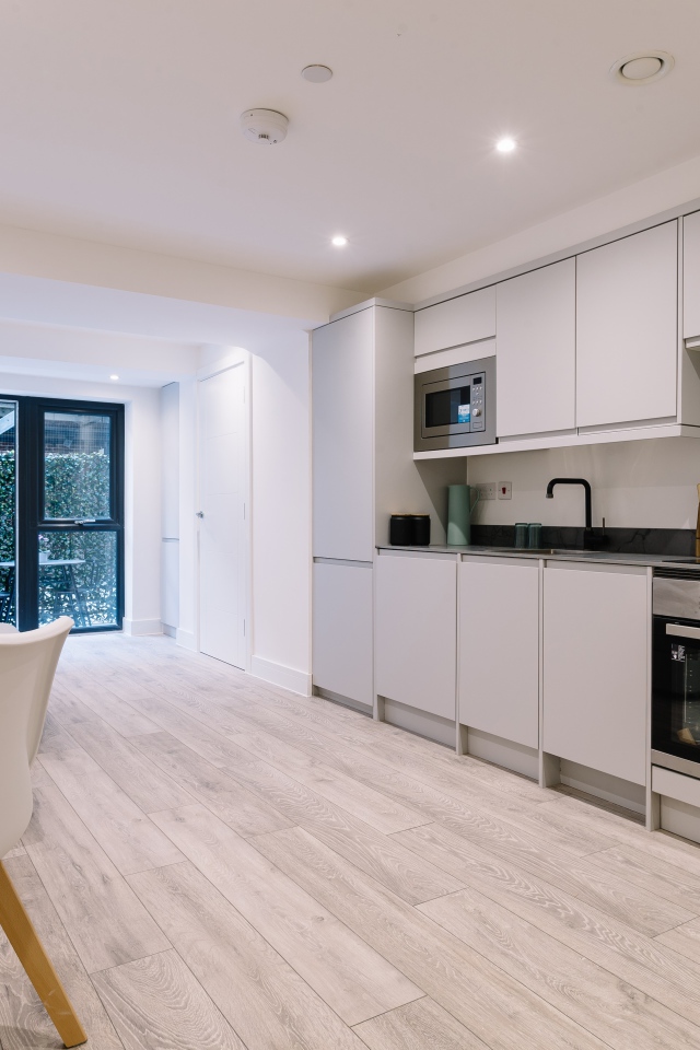 Большая просторная белая гостиная с букетом роз