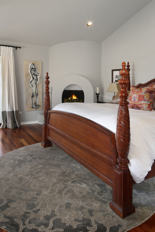 Large wooden bed in the bedroom with fireplace