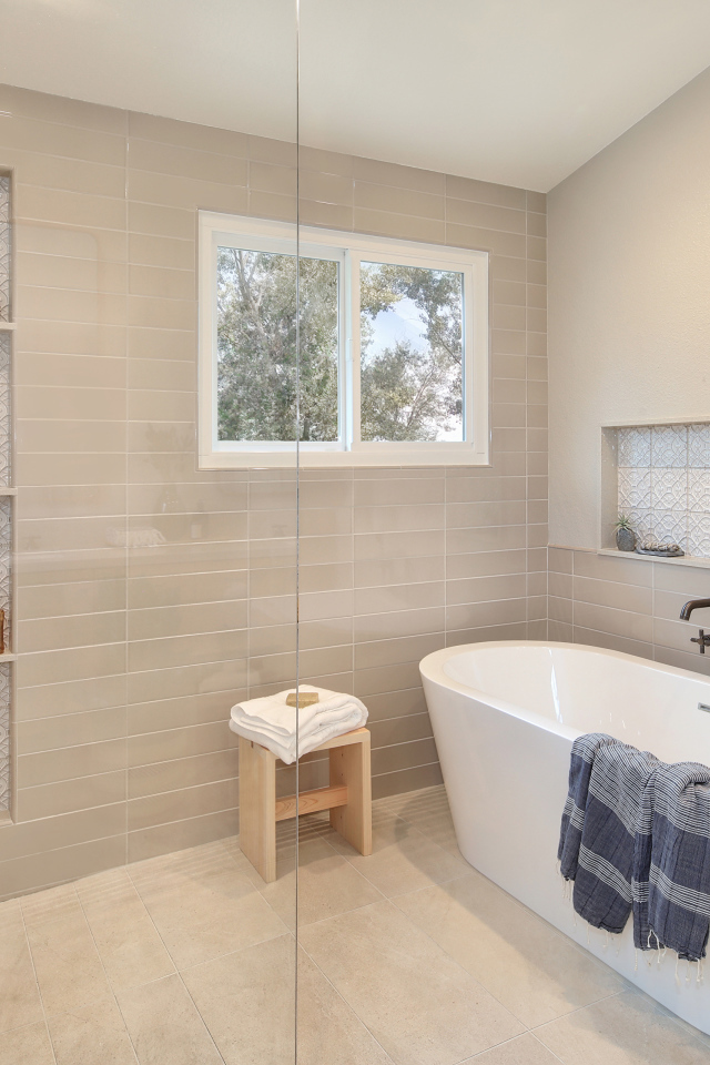 Душевая комната с белой ванной и серыми стенами