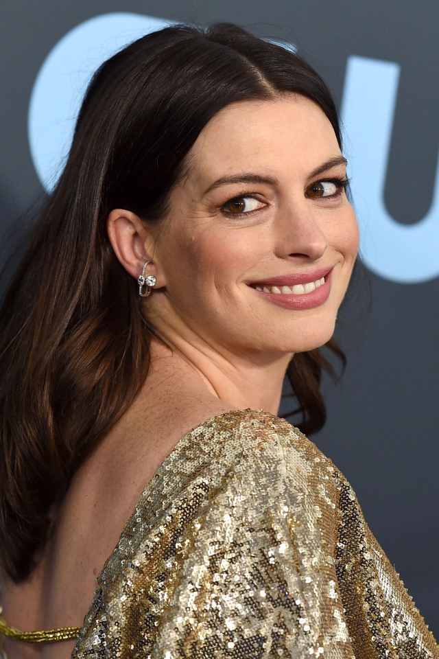 Улыбающаяся актриса Энн Хэтэуэй в ярком платье